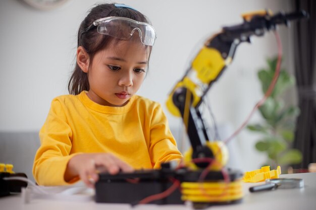STEM教育コンセプト アジアの生徒は自宅でロボットの腕をコーディングして学びます STEM数学 エンジニアリング 科学 テクノロジー 子供のためのロボティクスのコンピュータコード コンセプト