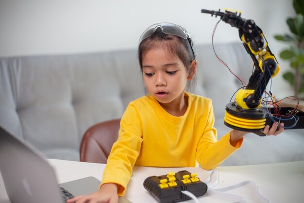 stem education concept asian students learn at home by coding robot arms in stem mathematics engineering science technology computer code in robotics for kids concepts
