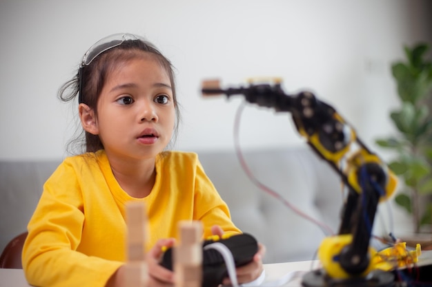 stem education concept asian students learn at home by coding robot arms in stem mathematics engineering science technology computer code in robotics for kids' concepts