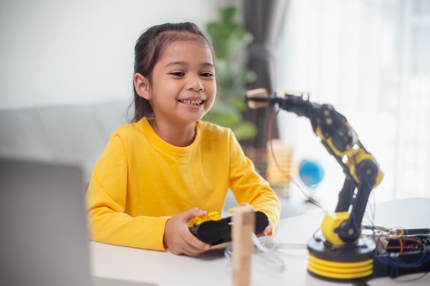 STEM教育コンセプトアジアの学生は、子供向けのコンセプトのためのロボット工学のSTEM数学工学科学技術コンピュータコードでロボットアームをコーディングすることによって自宅で学びます