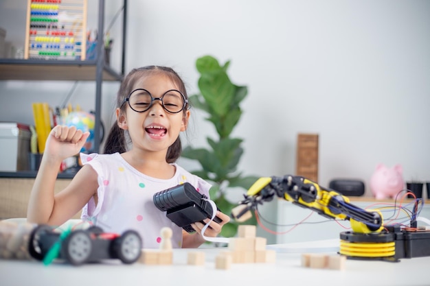 STEM education concept Asian students learn at home by coding robot arms in STEM mathematics engineering science technology computer code in robotics for kids' concepts