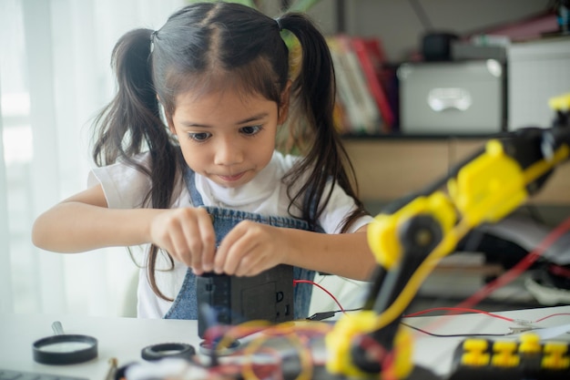 STEM education concept Asian young girl learning robot design