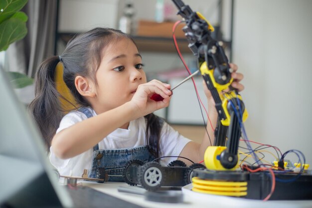 STEM education concept Asian young girl learning robot design