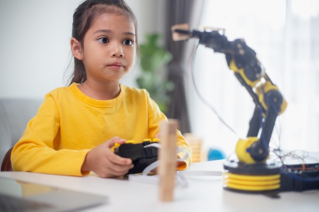 STEM-onderwijsconcept Aziatische studenten leren thuis door robotarmen te coderen in STEM wiskunde techniek wetenschap technologie computercode in robotica voor kinderconcepten