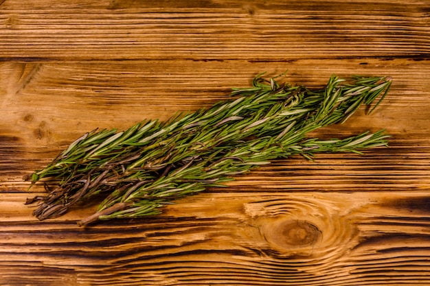 Foto gambo del rosmarino su tavola di legno rustica