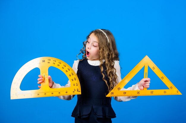 Foto discipline scolastiche stem alunna con grandi governanti piccola ragazza torna a scuola studente scolastico che impara lezione di matematica di geometria istruzione e conoscenza fiduciosi nel loro futuro di successo