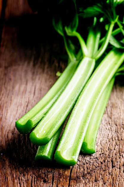 Stems of fresh celery with leaves on the table vintage wooden background selective focus