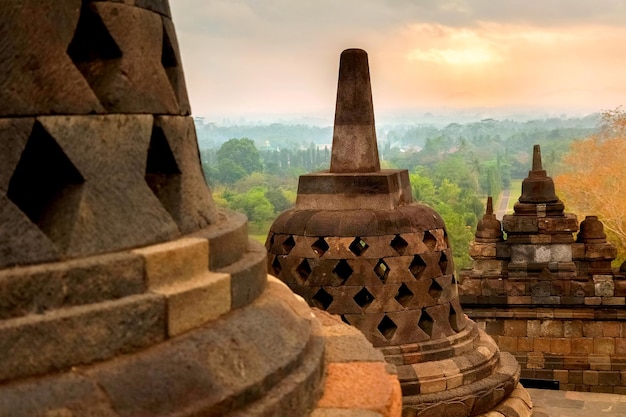 Stenen boeddhistische stoepa's tegen de achtergrond van de zonsopgang in de Borobudur-tempel Java Indonesië