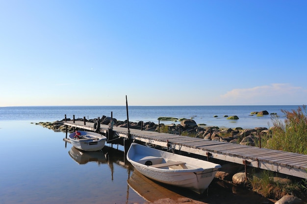 Stenen in het water oude houten pier met boten