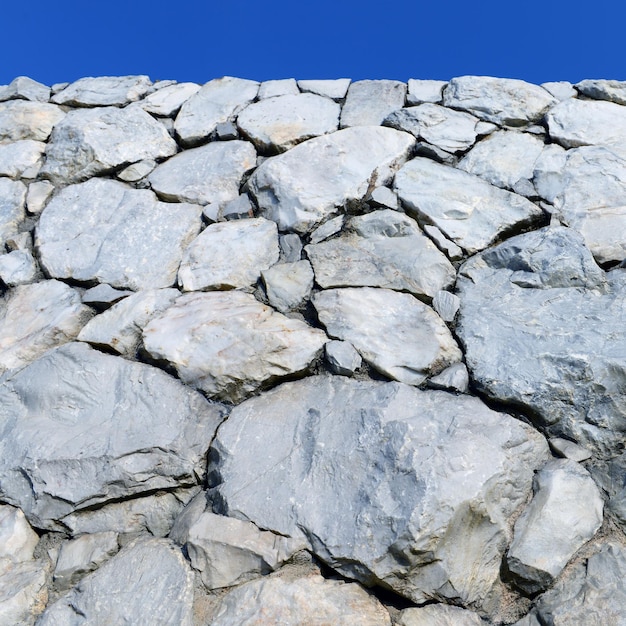 Stenen muur achtergrond en textuur met blauwe lucht