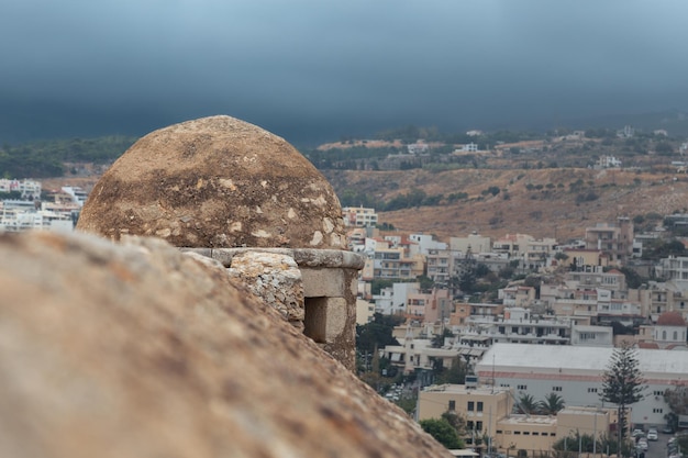 Stenen muur en kleine toren van het Venetiaanse fort Fortezza met stad op de achtergrond Rethymno, Griekenland