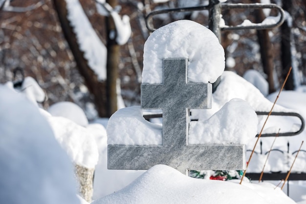 Stenen orthodoxe kruisiging in sneeuwjacht op begraafplaats