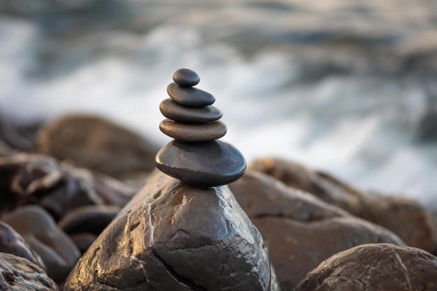 Stenen piramide op kiezelstrand symboliseert stabiliteit harmonie balans Ondiepe scherptediepte