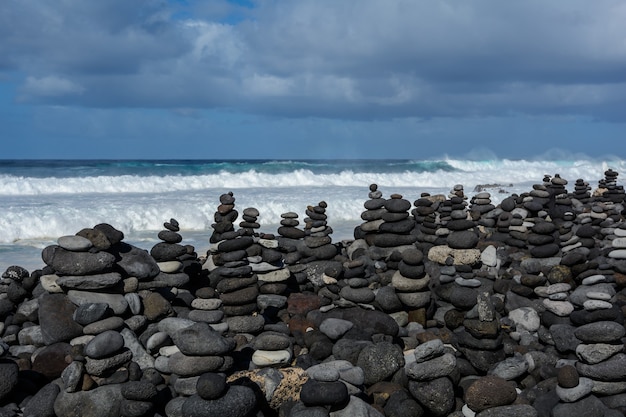 Stenen piramide op kiezelstrand symboliseert stabiliteit, zen, harmonie, balans. Ondiepe scherptediepte.