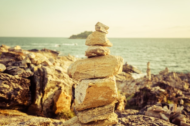 Stenen staan op een evenwichtsbalk, verlichte felle zon op eiland, natuurlijke zen-achtergrond