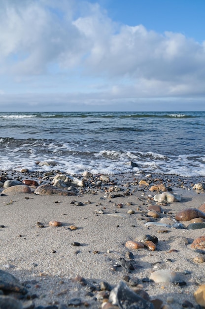 Stenen strand aan de kust van Denemarken Stenen in het zand en in het water