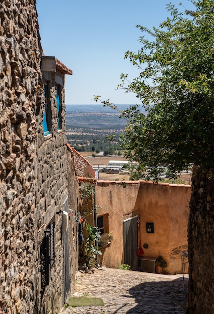 Stenen toren bij de oude stenen huizen en de smalle straat in de oude stad Castelo Rodrigo in Portugal