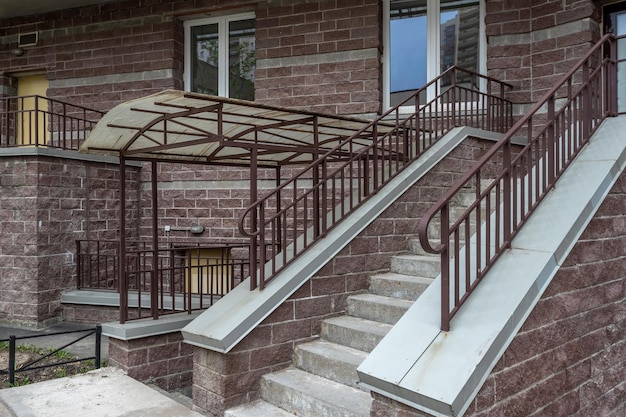 Stenen treden met metalen balustrades en hardboard overdekte veranda