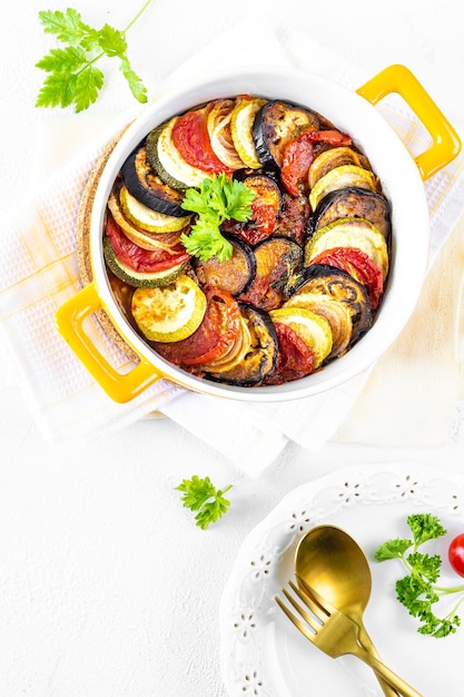 Step 1 Different vegetables A healthy diet Ingredients for baking Vegetable ratatouille on a white background Hands in the frame Top view