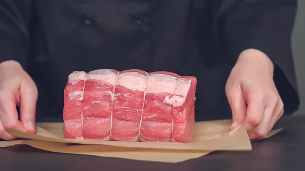 ステップバイステップ。茶色の肉屋の紙に骨なしのポークロースト。