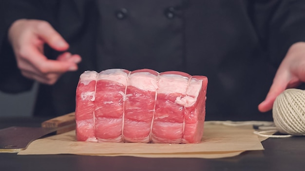 ステップバイステップ。茶色の肉屋の紙に骨なしのポークロースト。