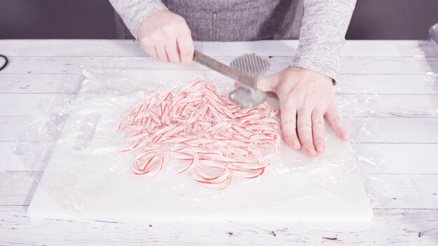 Step by step. Breaking candy cane candies into small pieces.