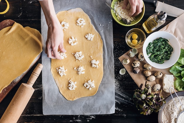 Step by step the chef prepares ravioli with ricotta cheese, yolks quail eggs and spinach with spices. The chef prepares the filling on the dough