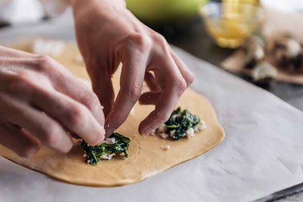 Step by step the chef prepares ravioli with ricotta cheese, yolks quail eggs and spinach with spices. The chef prepares the filling on the dough