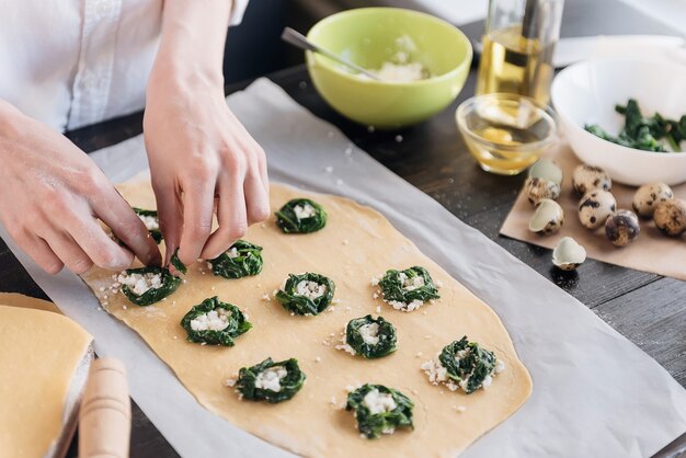 Step by step the chef prepares ravioli with ricotta cheese, yolks quail eggs and spinach with spices. The chef prepares the filling on the dough