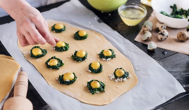 Step by step the chef prepares ravioli with ricotta cheese, yolks quail eggs and spinach with spices. The chef prepares the filling on the dough