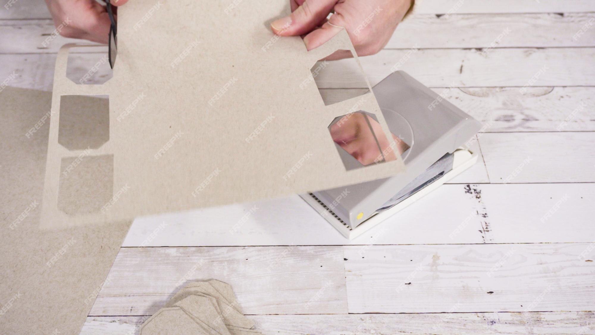 Premium Photo  Step by step. cutting out gift tags from brown paper with a paper  punch.