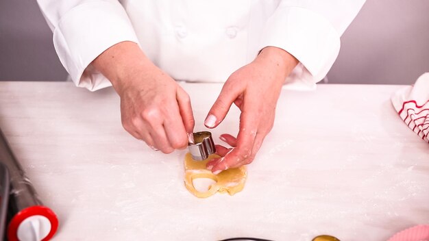 Step by step. Cutting out shapes from sugar cookie dough with cookie cutters.