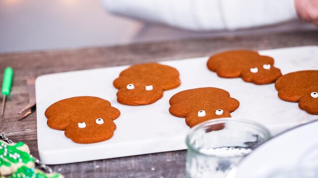 Step by step. Decorating gingerbread and sugar cookies with royal icing for Christmas.