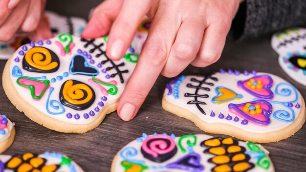 Photo step by step. decorating sugar skull cookies with different color royal icing.