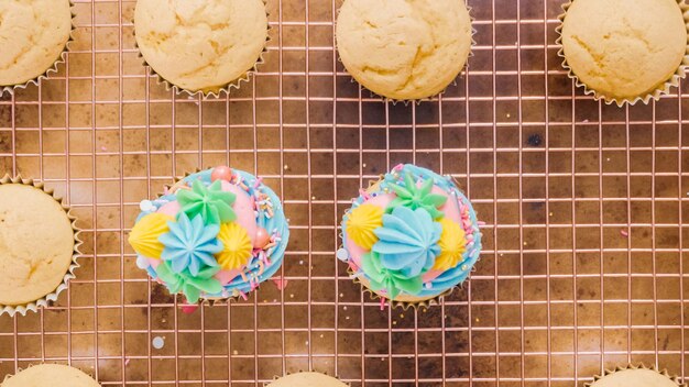 Step by step. decorating unicorn themed vanilla cupcakes with rainbow buttercream frosting