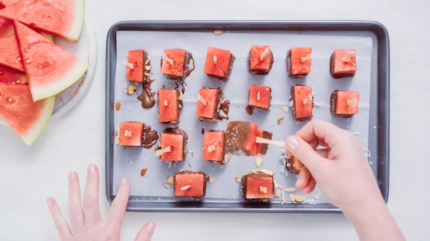 Step by step. Dipping watermelon cubes into melted chocolate and garnishing with sea salt and almonds.