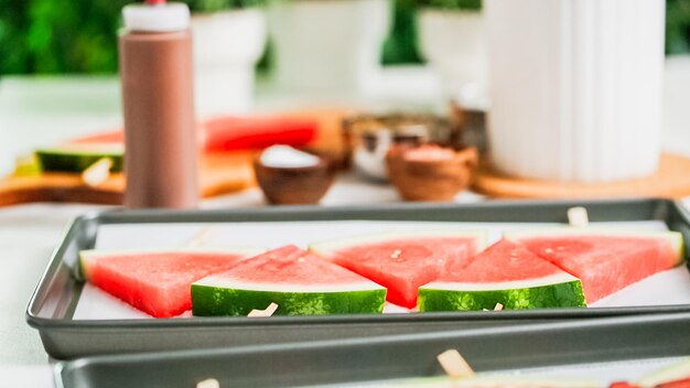 Step by step. Drizzling chocolate on watermelon ice pops.