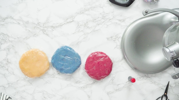 Step by step. Flat lay. Mixing food coloring into the cookie dough to bake red, white, and blue pinwheel sugar cookies.