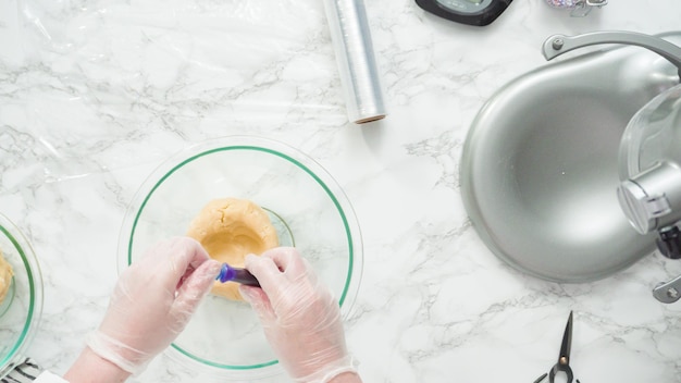 Step by step. Flat lay. Mixing food coloring into the cookie dough to bake red, white, and blue pinwheel sugar cookies.