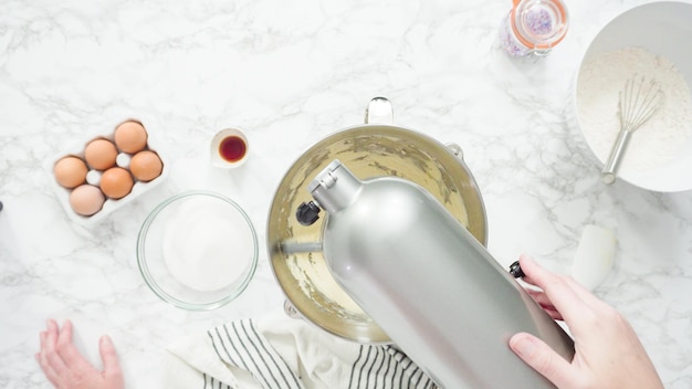 Step by step. Flat lay. Mixing ingredients in standing kitchen mixer to bake sugar cookies.