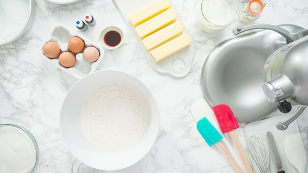 Step by step. Flat lay. Mixing ingredients in standing kitchen mixer to bake a three-layer vanilla cake.