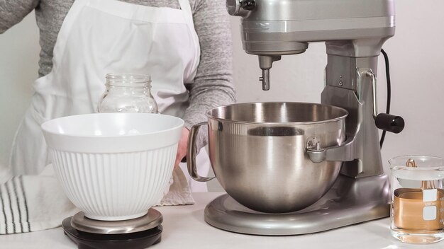 Step by step. Flat lay. Mixing royal icing in electric kitchen mixer for Easter cookies.