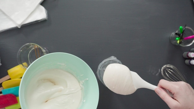 Step by step. Flat lay. Pouring royal icing into the piping bag to decorate sugar cookies.