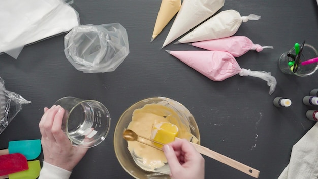 Step by step. Flat lay. Pouring royal icing into the piping bag to decorate sugar cookies.