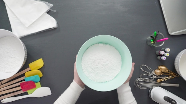 Step by step. Flat lay. Preparing simple royal icing to decorate sugar cookies.