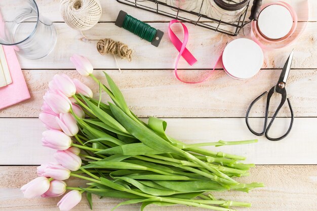 Step by step. Florist wrapping pink tulips in bouquet.