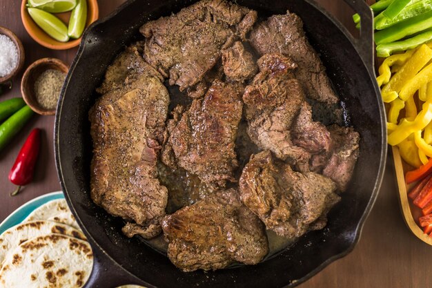 Step by step. Frying beef flank steak in cast iron frying pan for steak fajitas.