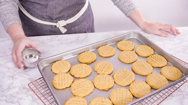 Step by step. Garnishing freshly baked peanut butter cookies with salt.