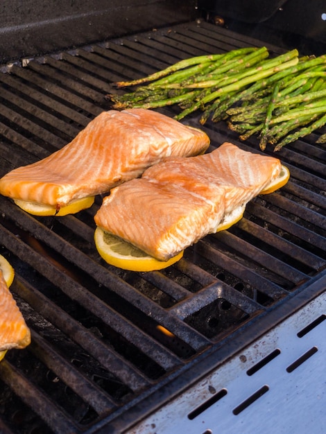Photo step by step. grilling salmon with lemons on outdooor gas grill.