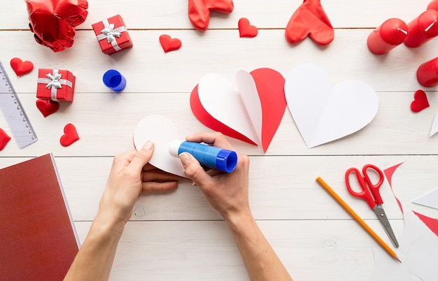 Step by step instruction making paper heart shape hot air balloon. Step 5 - glue white sides of hearts to each other so they form a dimensional heart